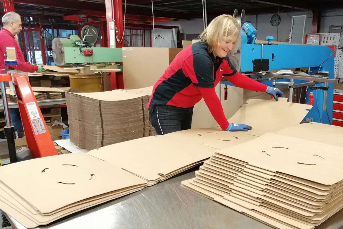 Eine Mitarbeiterin konfektioniert Drahtgitterverpackungen